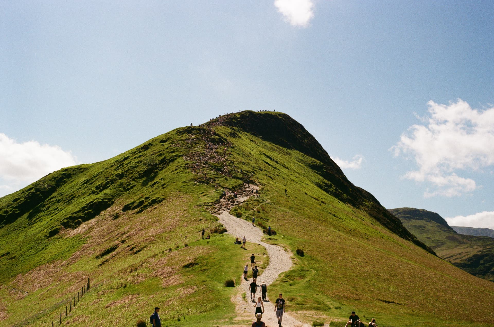 Hikers on a green ridge in the Lake District on film